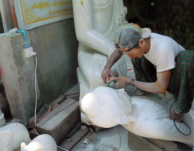 Ein Burmese bearbeitet eine Buddha-Figur aus Marmorstein